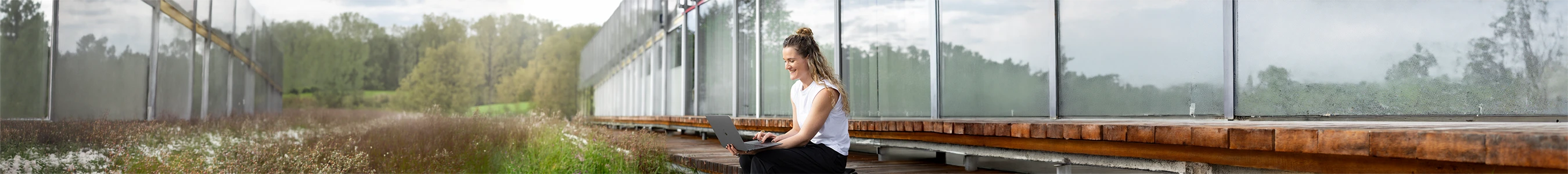 Nadja Hollstein sitzt mit ihrem Laptop im Freien.